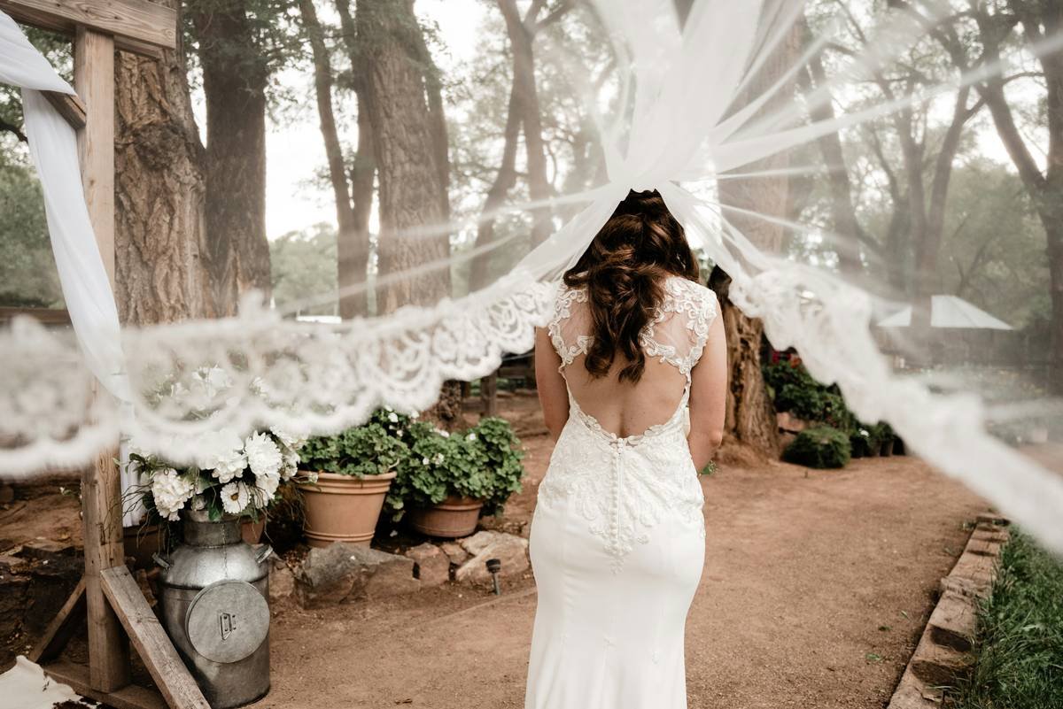 Side-by-side of two brides: one wearing an oversized beaded veil that overwhelms her simple gown, another with delicate seed-beaded veil complementing her silhouette