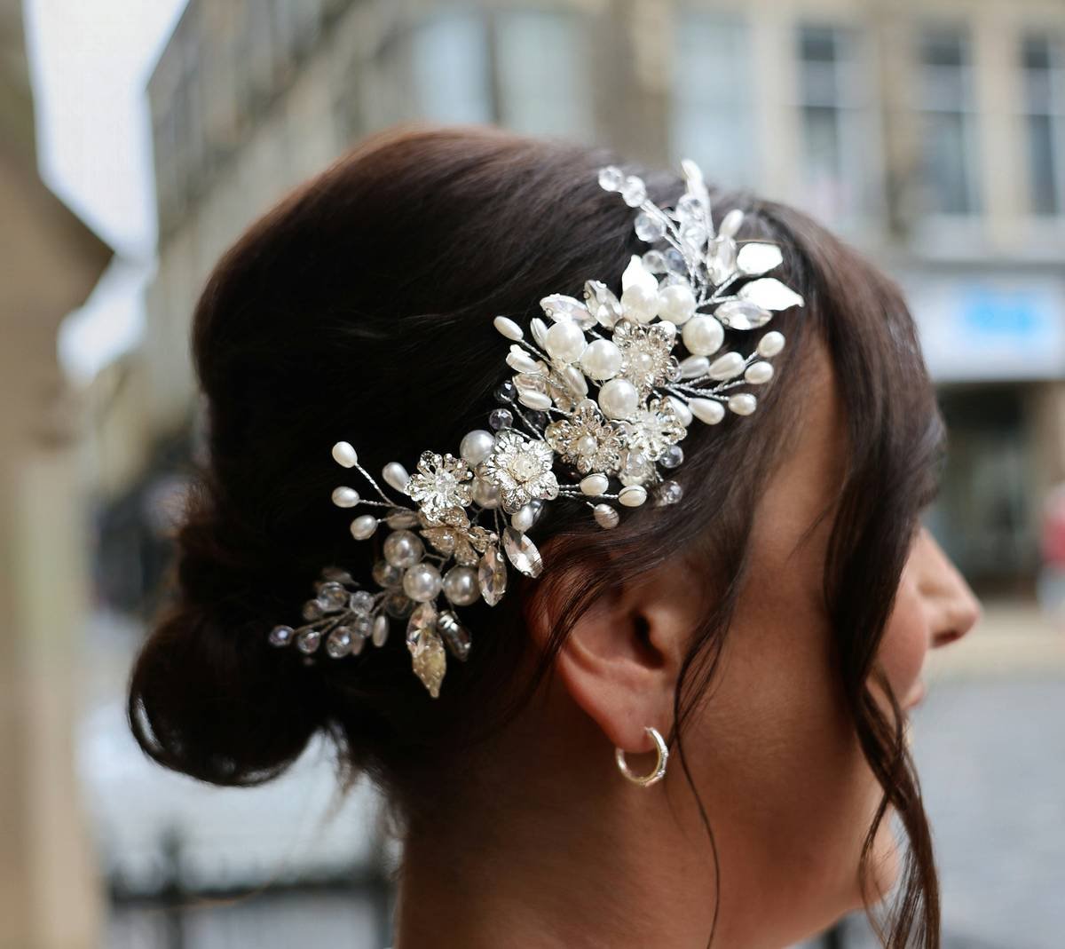 Close-up of handmade cultural headpiece showing embroidered lace and vintage pin details